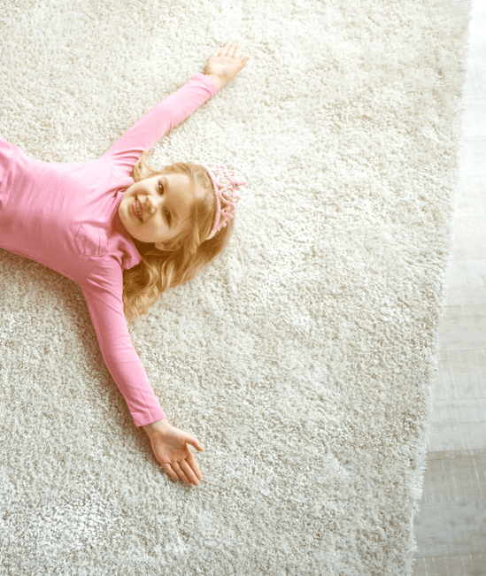 Cute girl laying on rug | Rocky Mountain Flooring