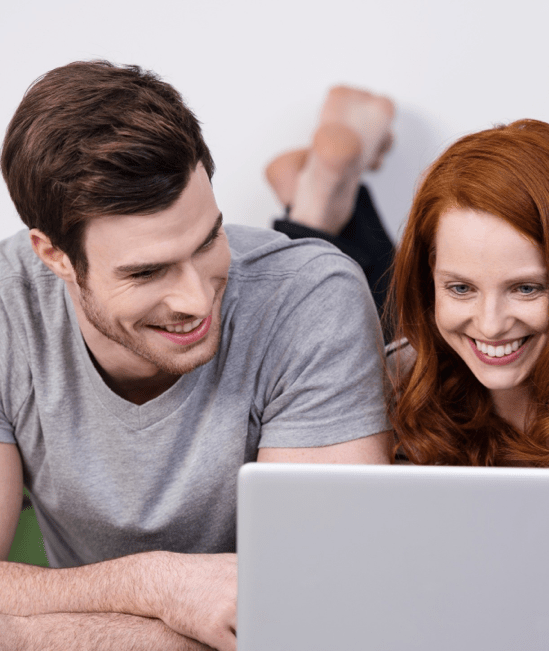Happy couple with laptop | Rocky Mountain Flooring